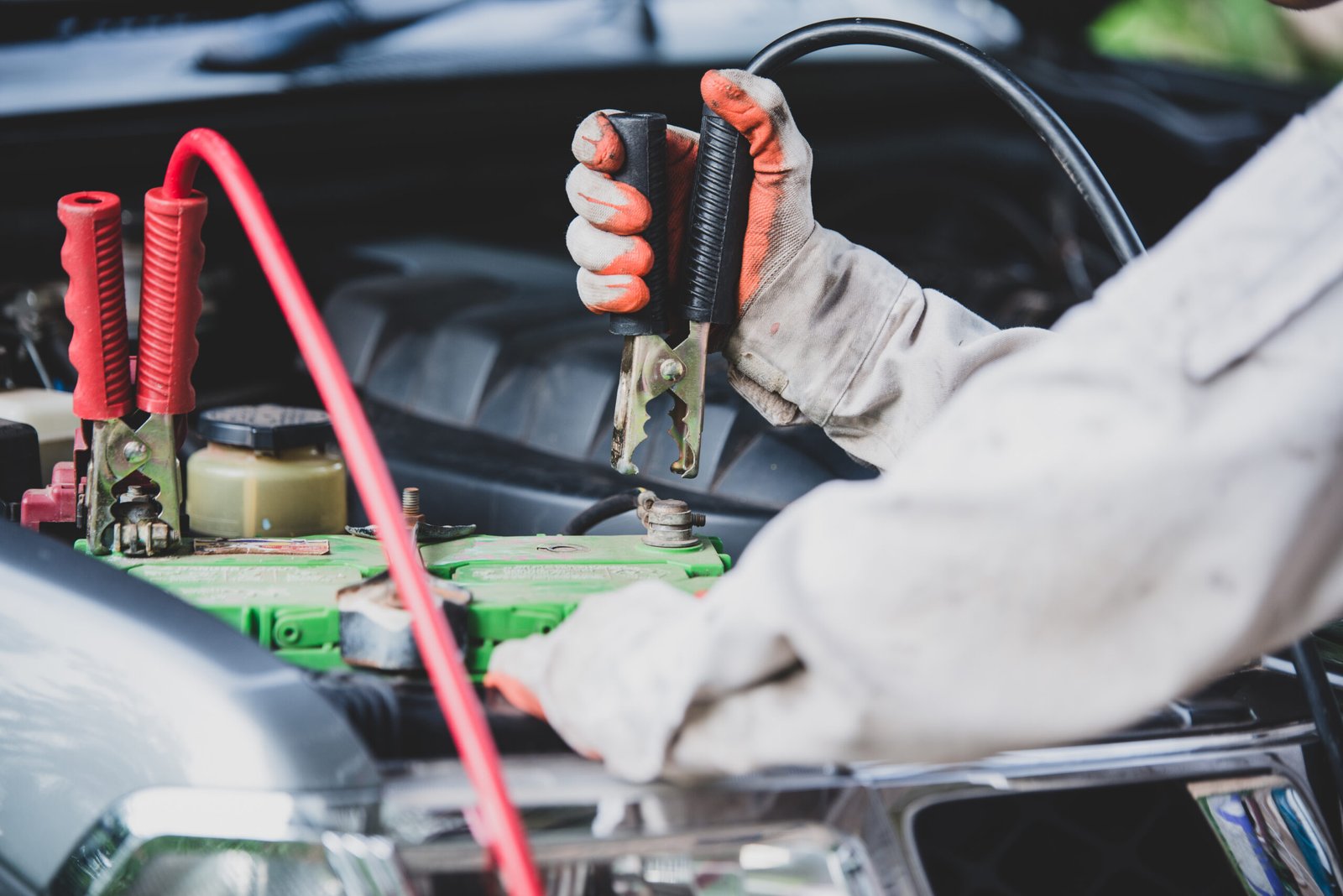 Home car repairman wearing a white uniform standing and holding a wre
